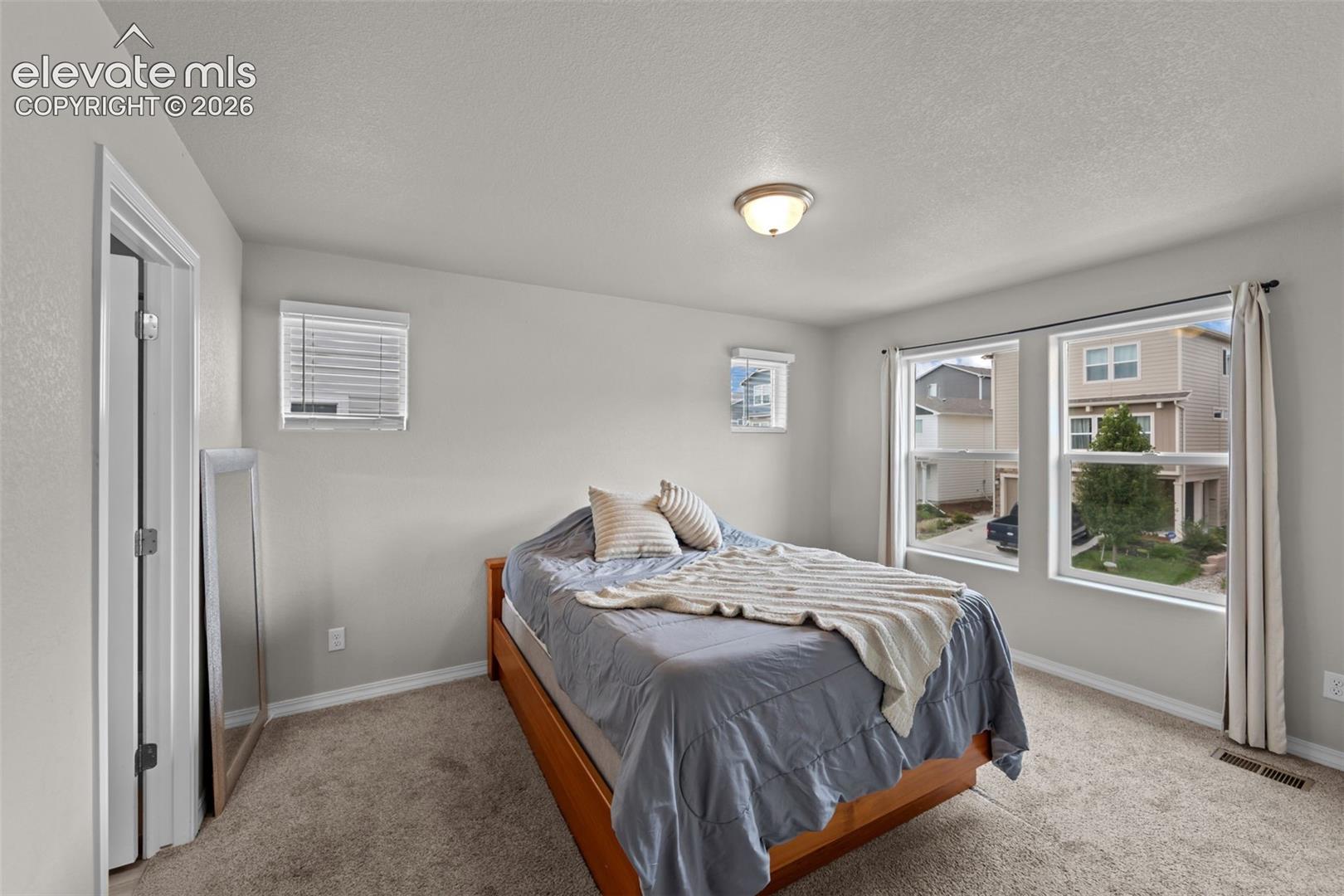 Carpeted flooring, recessed lighting, and multiple windows with blinds
