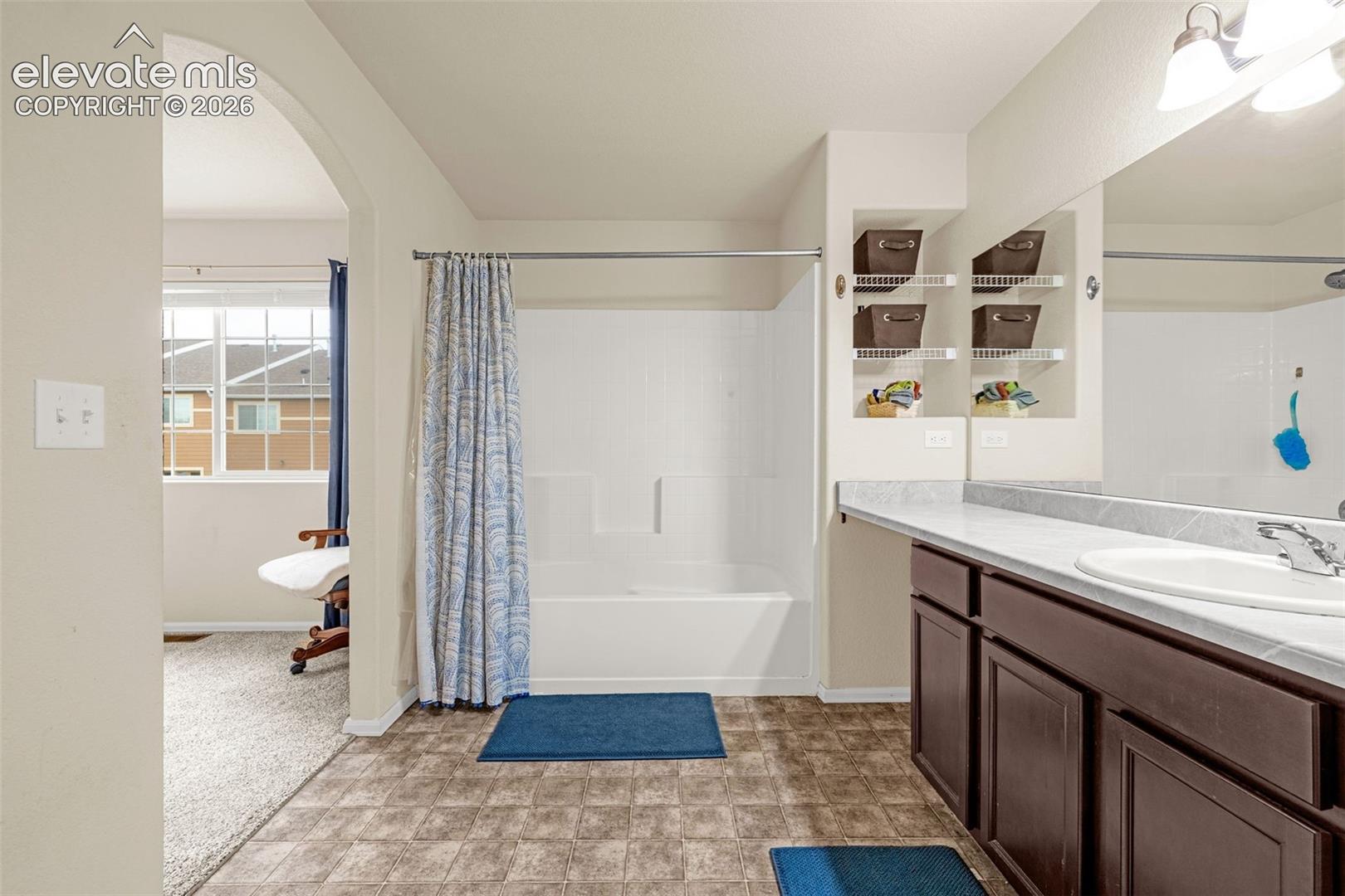 Brown wood-finish vanity with a white countertop and integrated sink