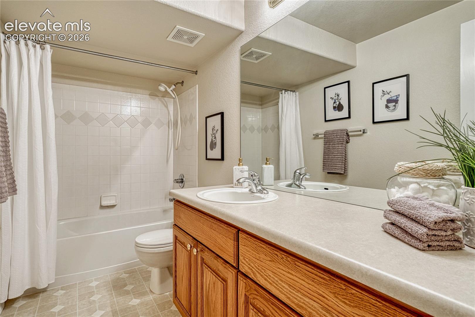 The third full bathroom located in the basement includes an oak vanity, neutral counters, and a tub/shower setup
