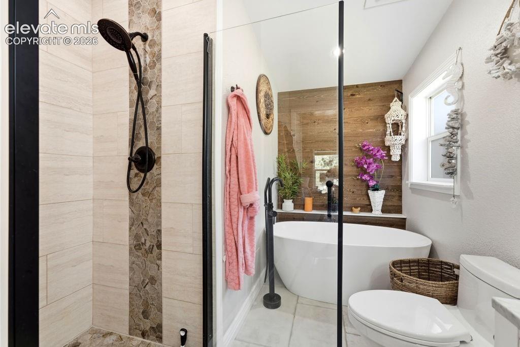 Walk-in shower with stone-look tile surround and dark bronze fixtures