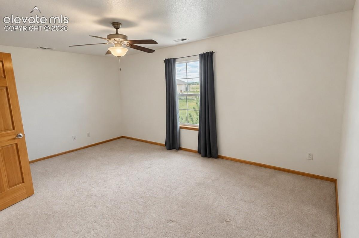 Upsatairs bedroom 3/3. Recessed lighting, ceiling fan with integrated light fixture, light-toned carpet flooring, neutral wall tones, a wood-frame window, & large walk-in closet. No staging.