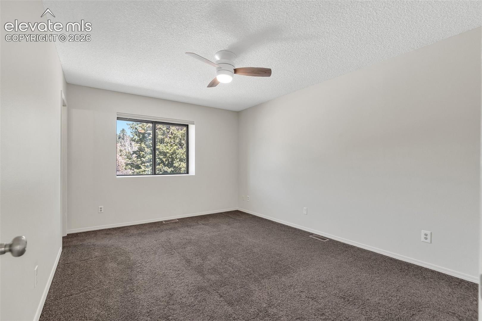 Recessed window, ceiling fan with integrated lighting, wall-to-wall carpeting, and neutral wall tones