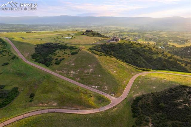 Wide aerial of Tessa Mesa's winding private roads and rolling landscape, with the estate perched at the summit.