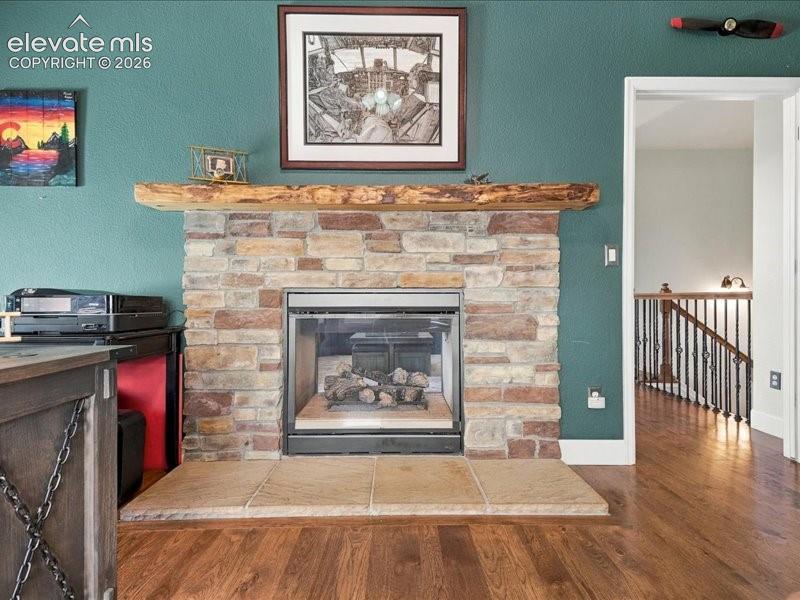 Stone-clad fireplace with a natural wood mantel