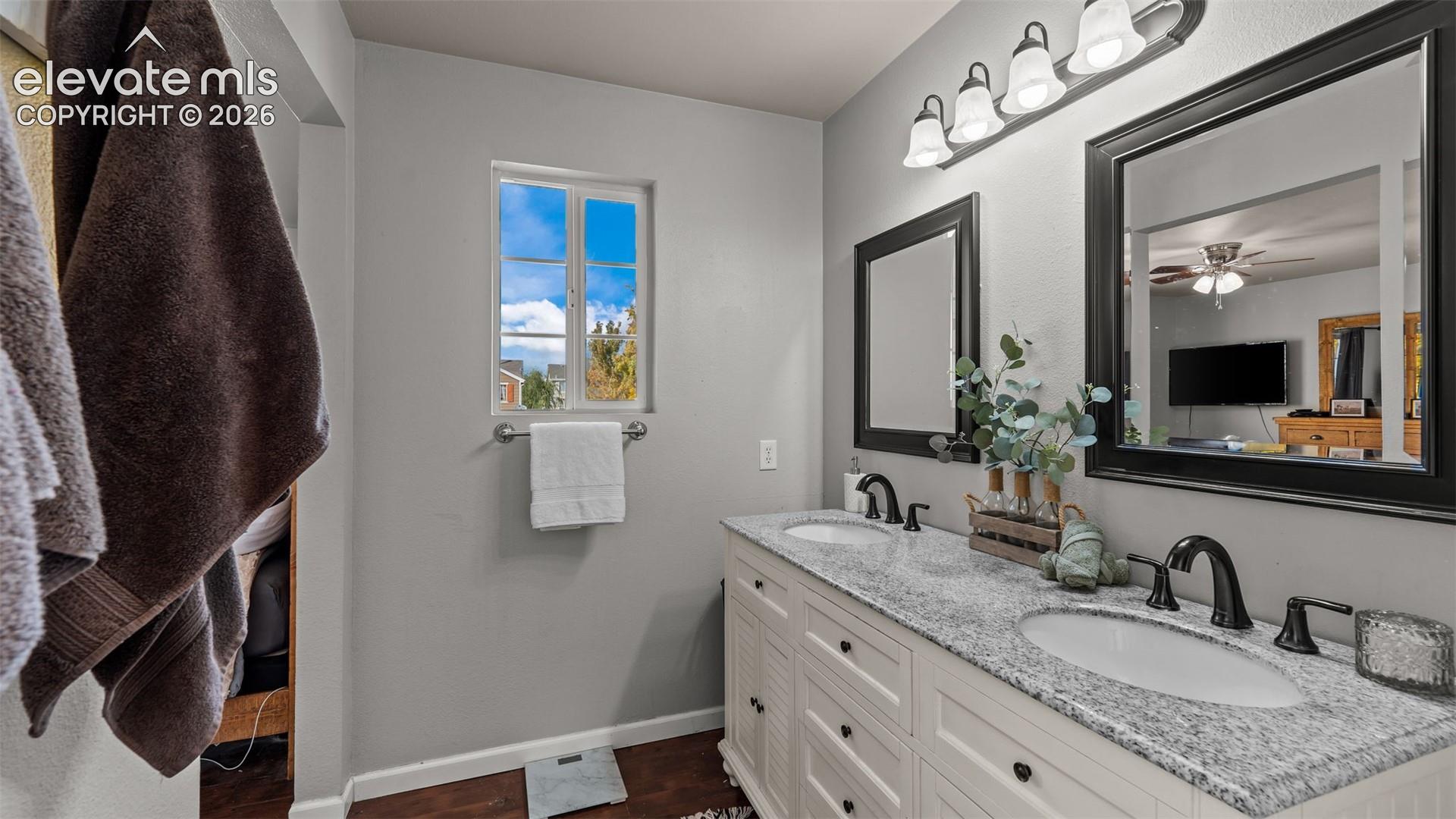 Double vanity with granite-style countertop, dual sinks, and matte black fixtures