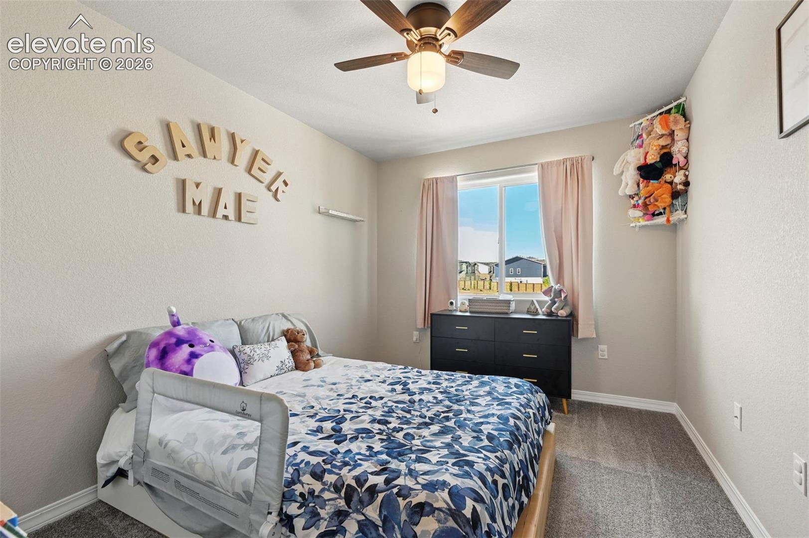 Room featuring a window with natural light, a ceiling fan with integrated lighting, and neutral wall tones