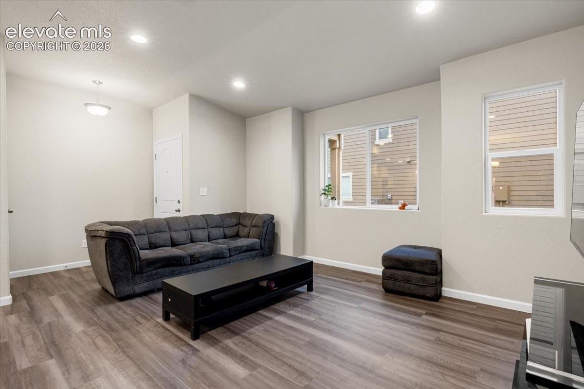 Recessed lighting, wood-finish flooring, light-toned walls, and white trim