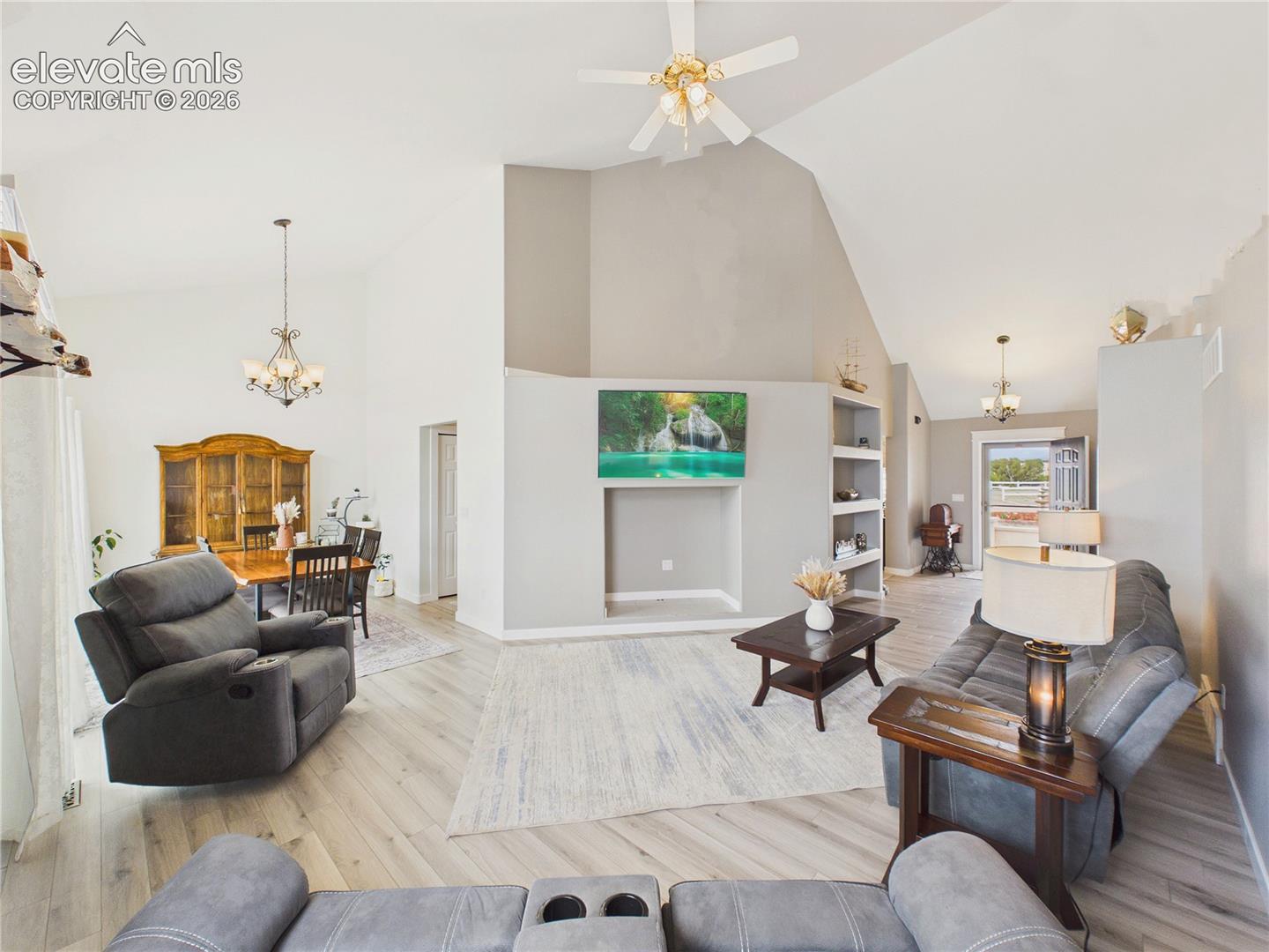 Open-concept great room showcases soaring ceilings, expansive sightlines, and seamless flow between the living and dining spaces.