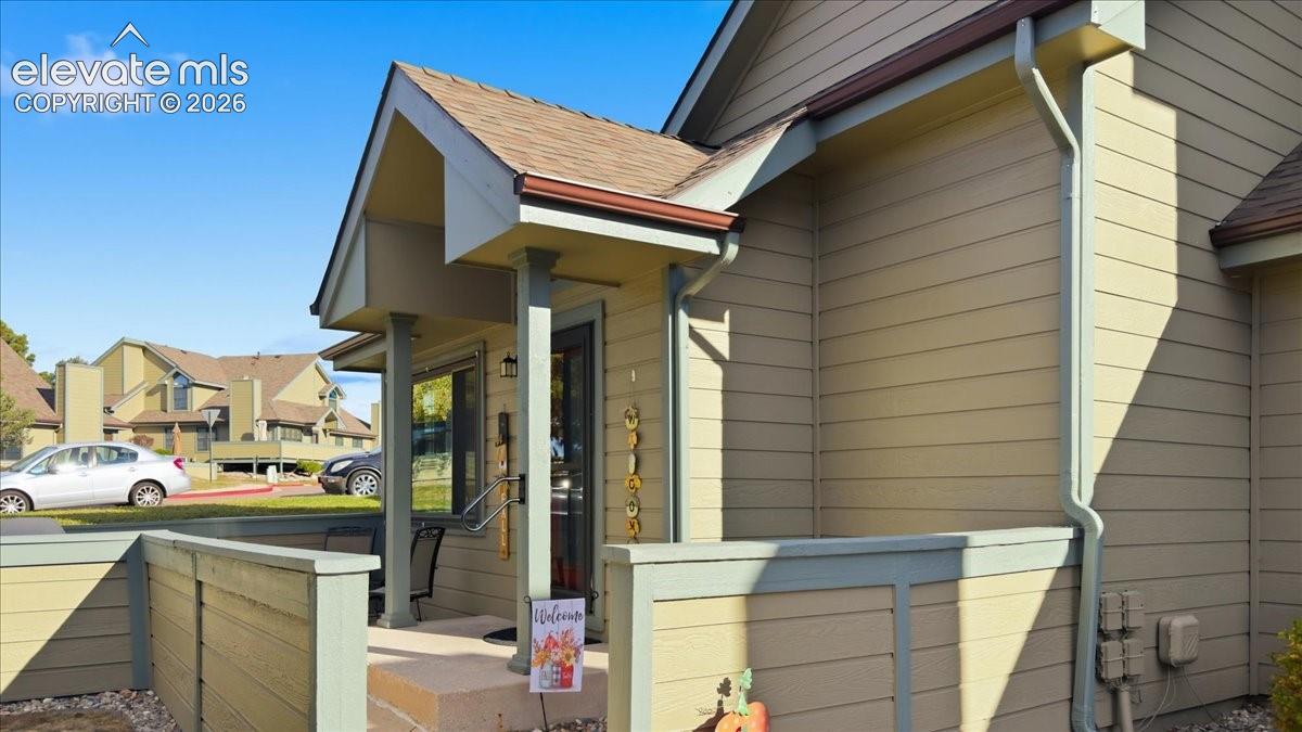 Exterior featuring horizontal lap siding, a covered entryway with a gabled roofline, a column-supported porch, and a private wooden privacy wall