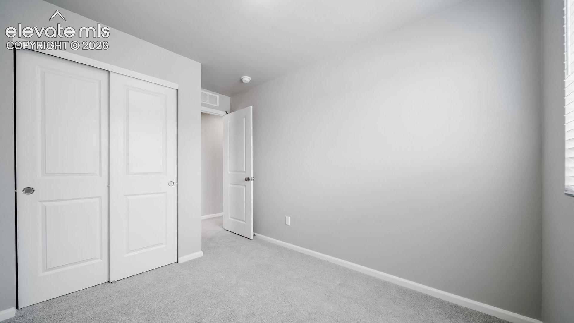 Neutral-toned wall paint, wall-to-wall carpeting, sliding closet doors with recessed panels, and a standard swinging interior door
*photos of a model home*