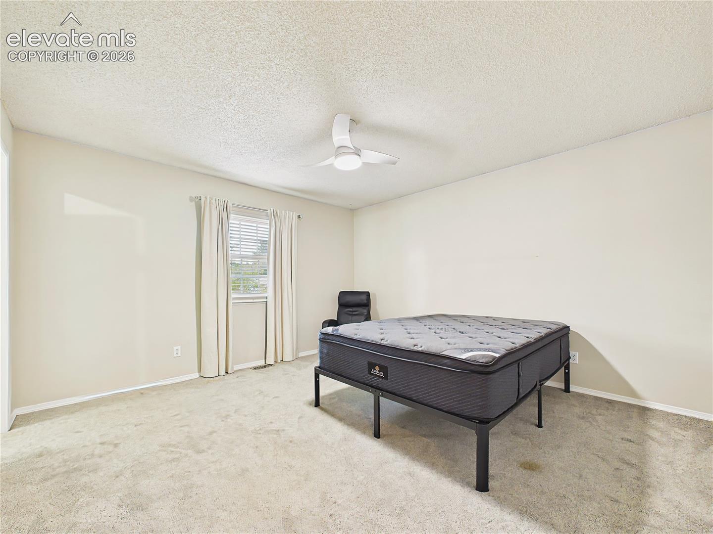 Bright and comfortable primary suite with a large window, updated ceiling fan, and a flexible layout for additional seating or furnishings. Up Stairs