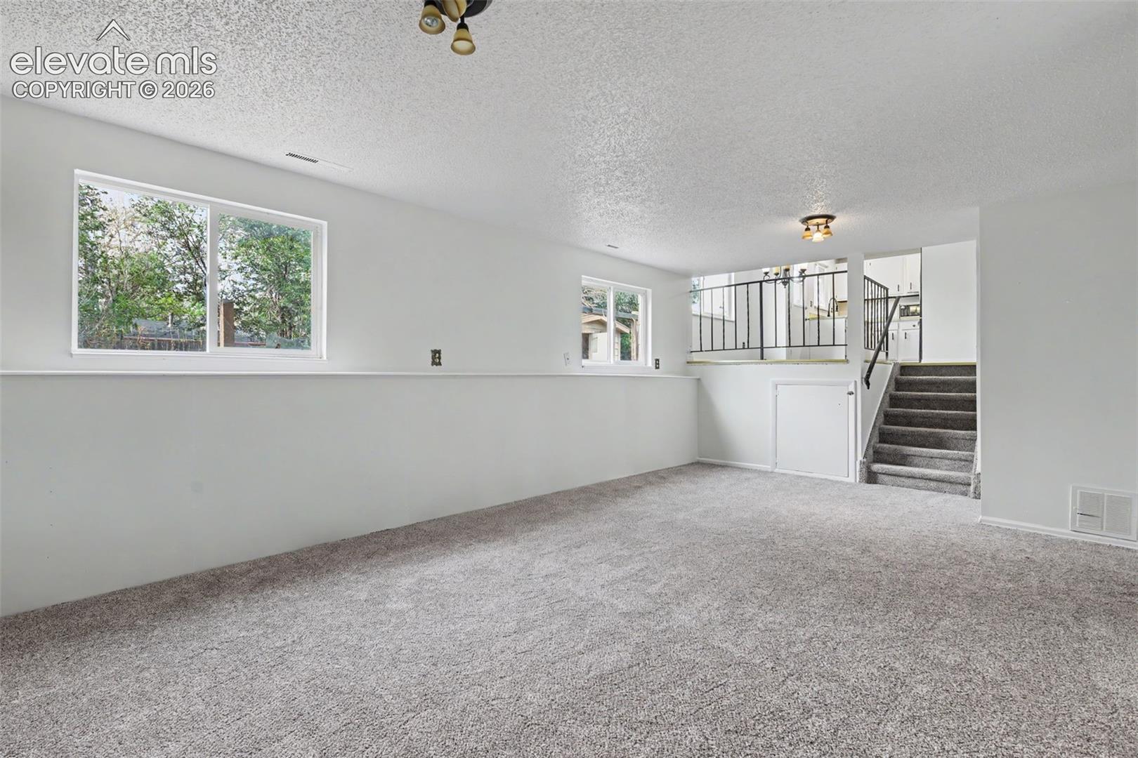 Lower level family room with open flow to the kitchen and upper level living spaces.