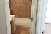 Full bathroom featuring a tub-shower combination with tile surround, a built-in vanity, and neutral tile flooring