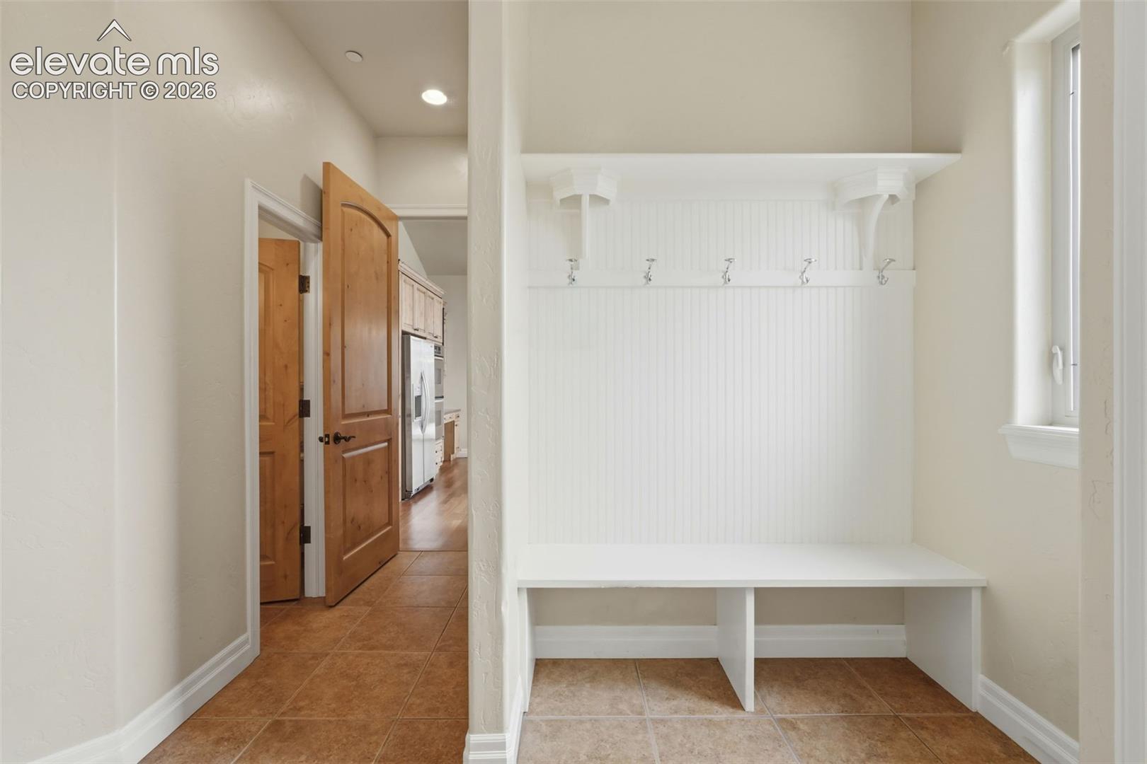 Built-in mudroom bench with beadboard backing and wall hooks