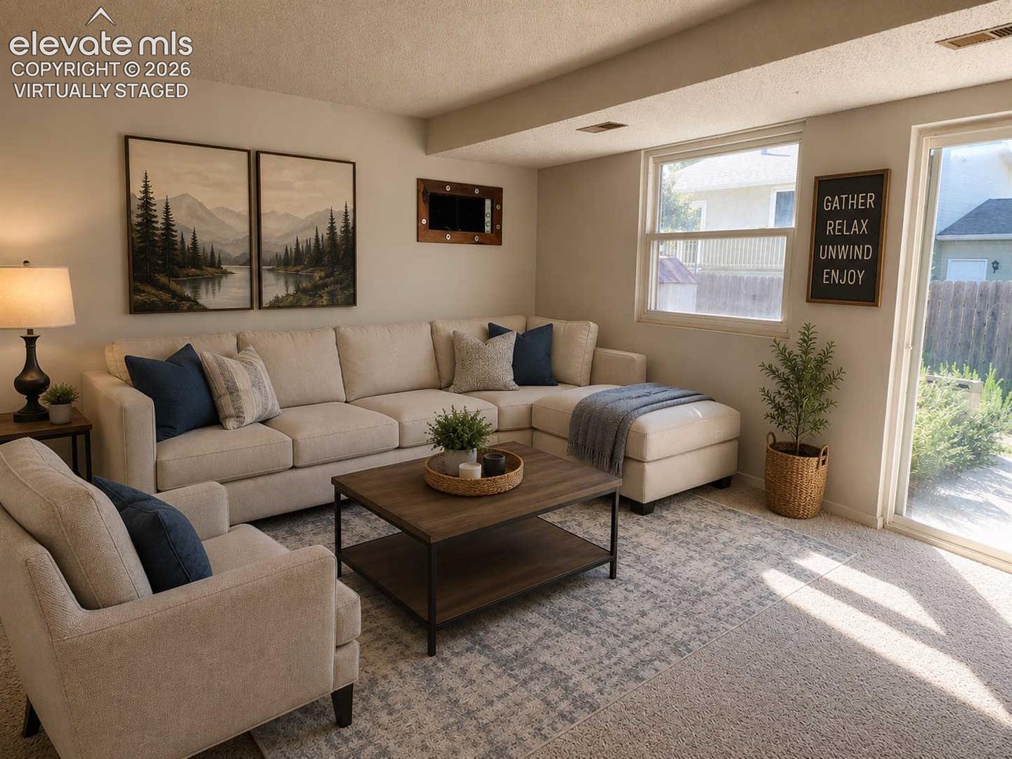 Carpeted family room featuring a large window and sliding glass door - virtually staged