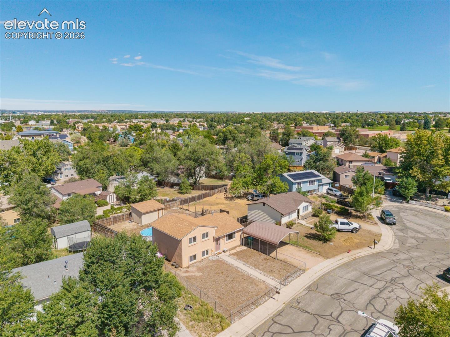 Spacious lot featuring a detached carport, fenced yard, and an above-ground pool on a quiet street conveniently located near Ft. Carson. 