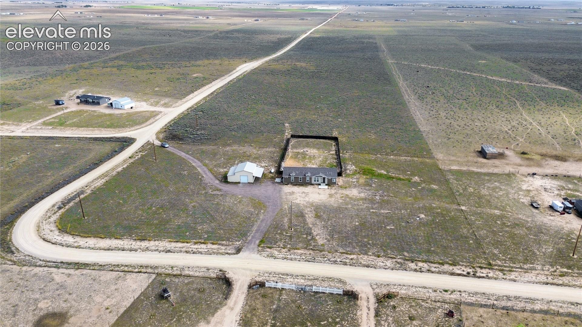 Expansive acreage featuring a detached workshop, gravel driveway, and a fenced rear perimeter