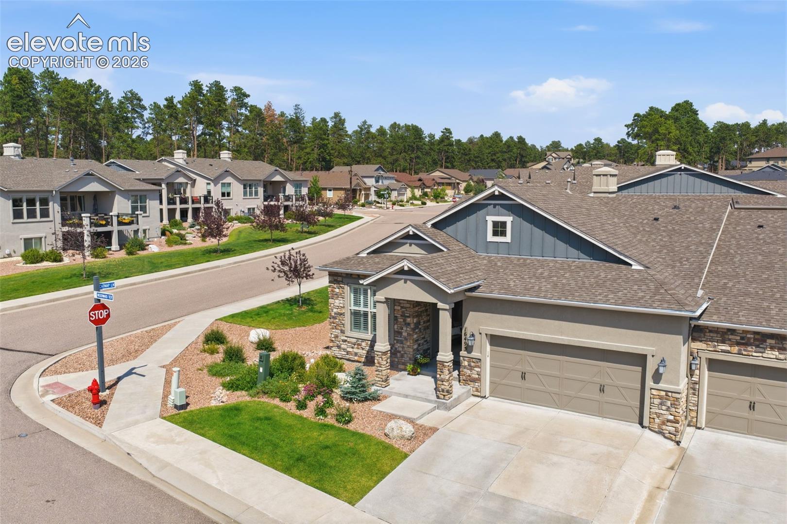Stucco and stone facade with board-and-batten accent siding.