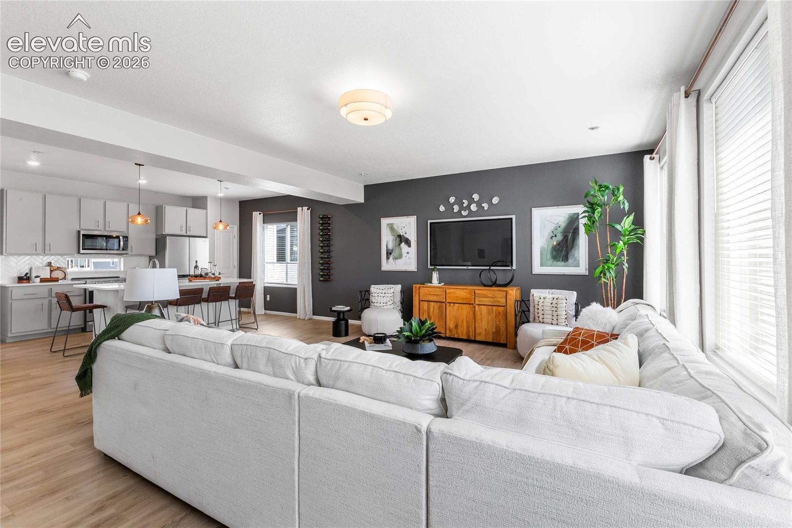 Open-concept living area featuring wood-finish flooring, recessed lighting, and ample natural light
*photos of a model home*