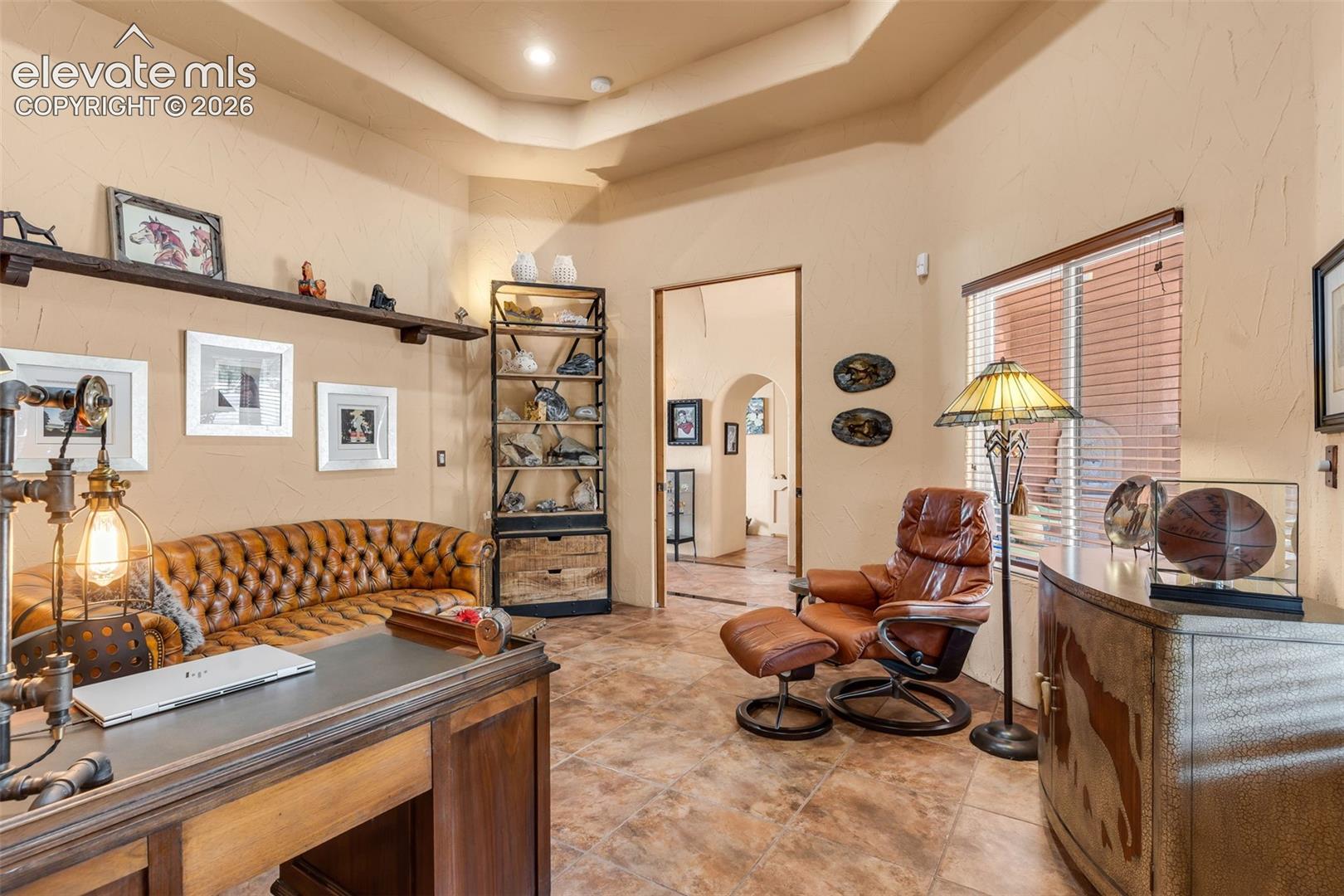 Tray ceiling, stone-finish tile flooring, and wall-mounted shelving unit