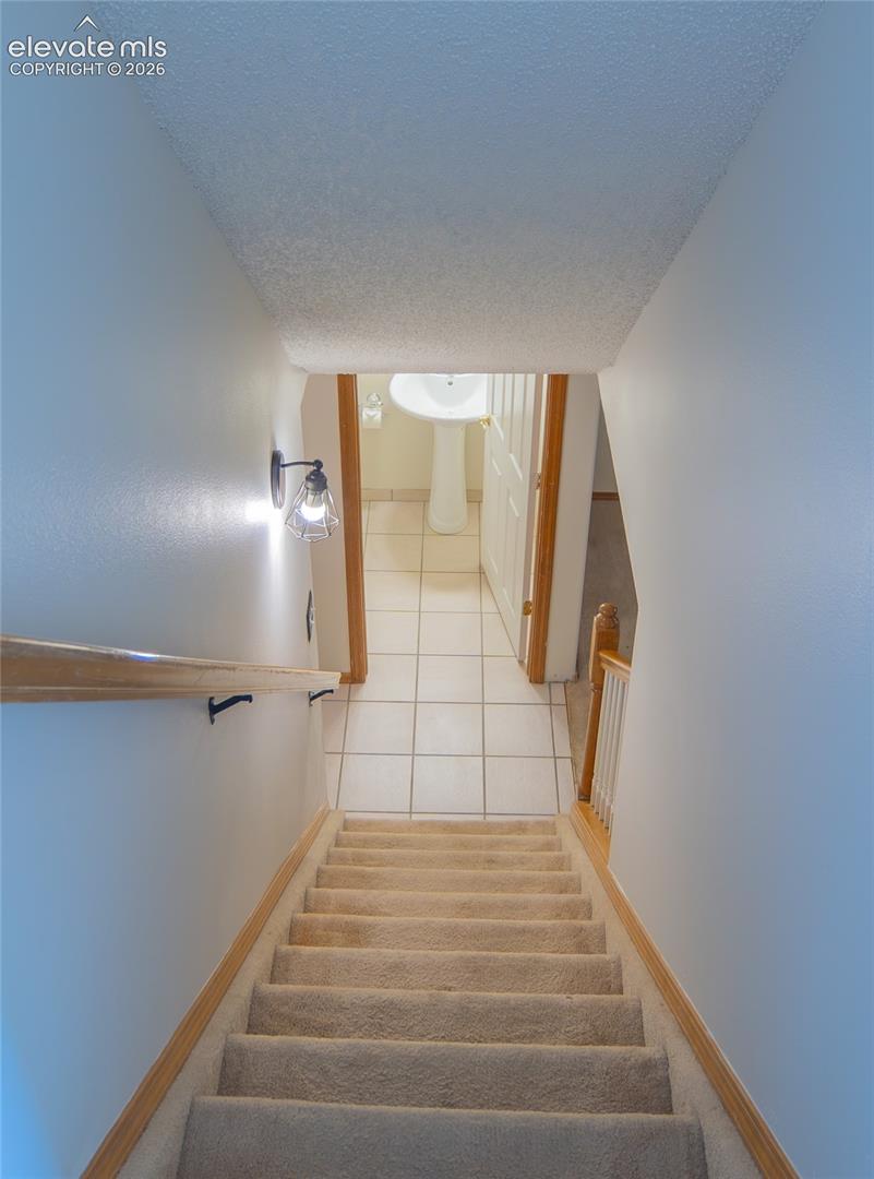 Carpeted stairway leads to the finished basement, providing additional living space.