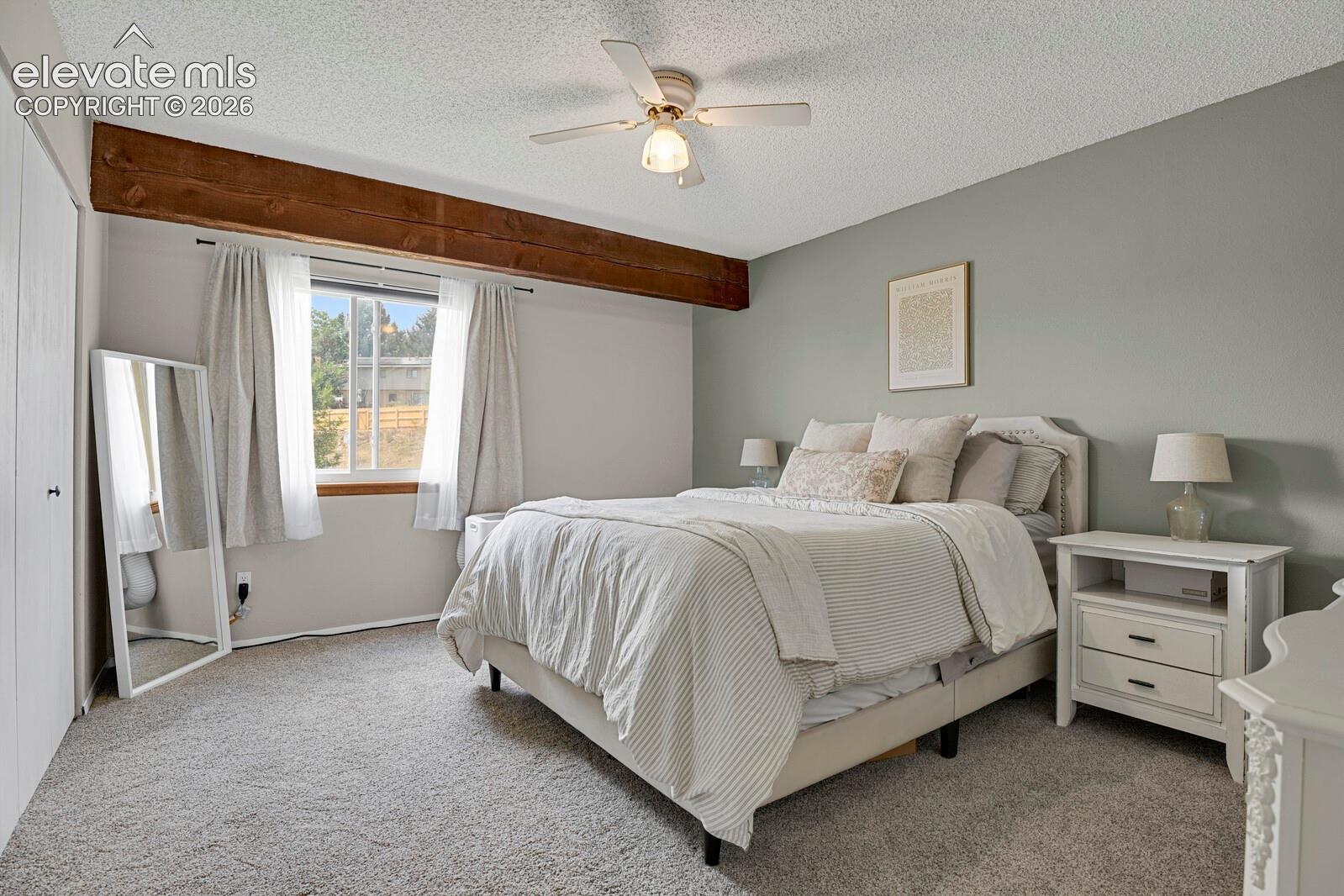 Ceiling fan light fixture, exposed wood beam, window with white trim, and light gray wall paint