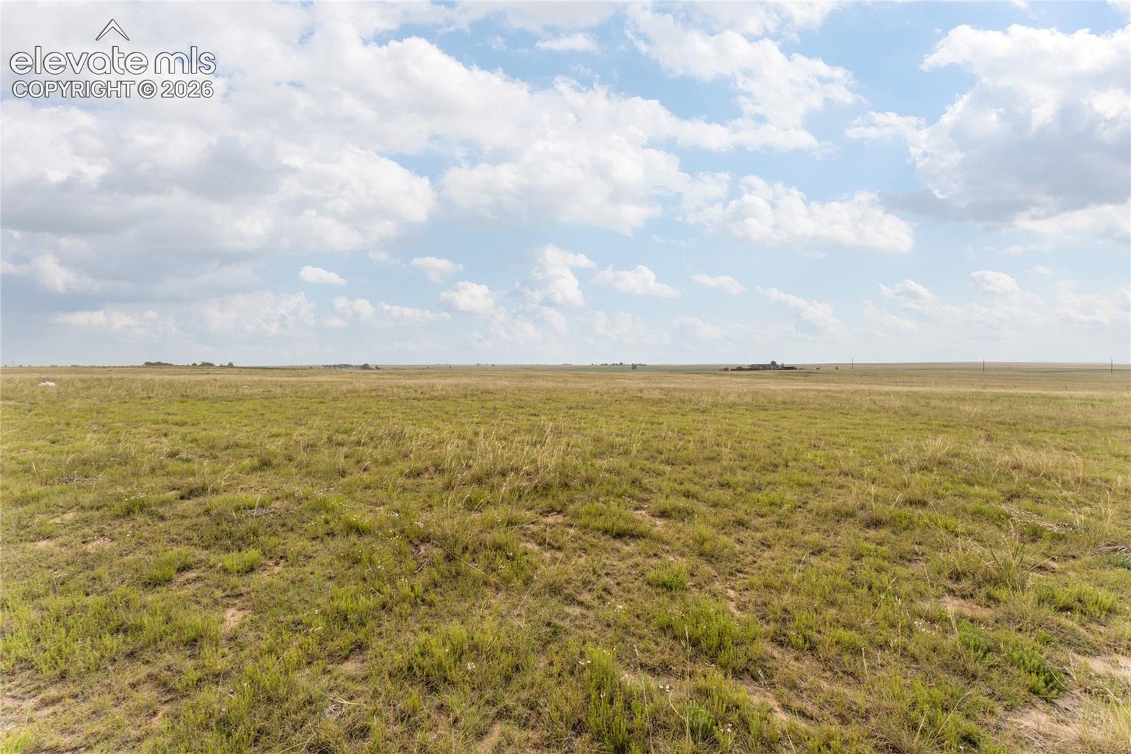 Expansive open acreage featuring natural grasslands and a distant horizon