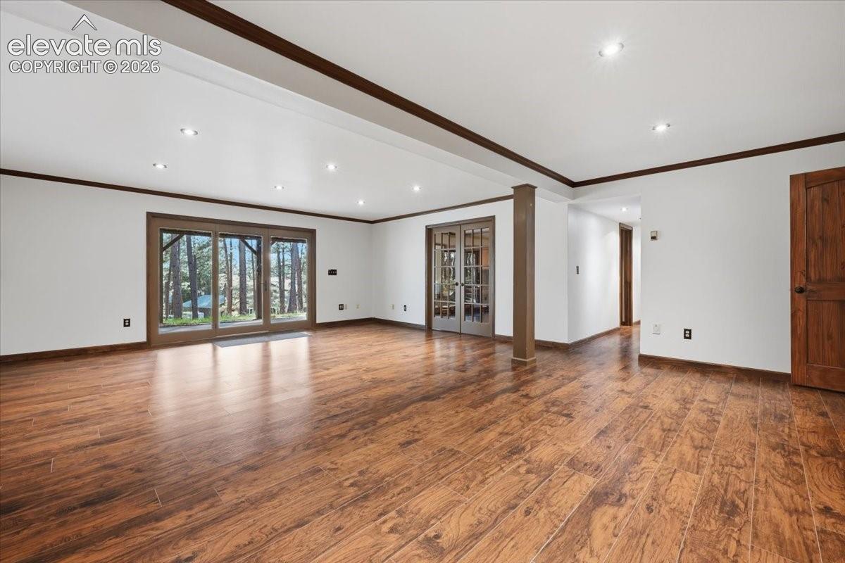 Expansive interior with wood-finish flooring, recessed lighting, and white walls