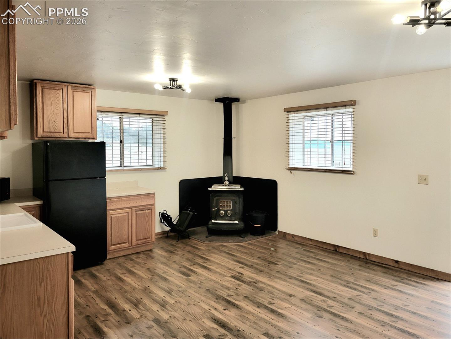 The property features a wood stove, laminate wood flooring, kitchen cabinetry