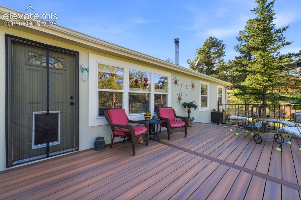 Expansive composite deck with a black metal railing and multiple windows