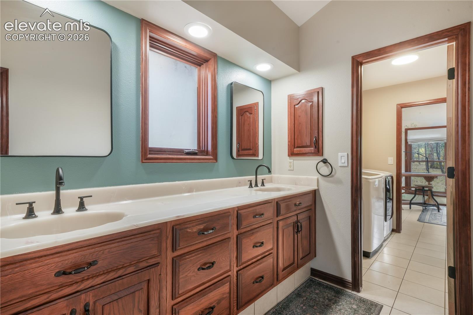 Primary bathroom with tile flooring and dual vanity