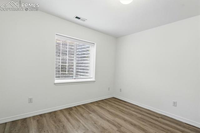 Unfurnished room featuring wood finished floors and baseboards