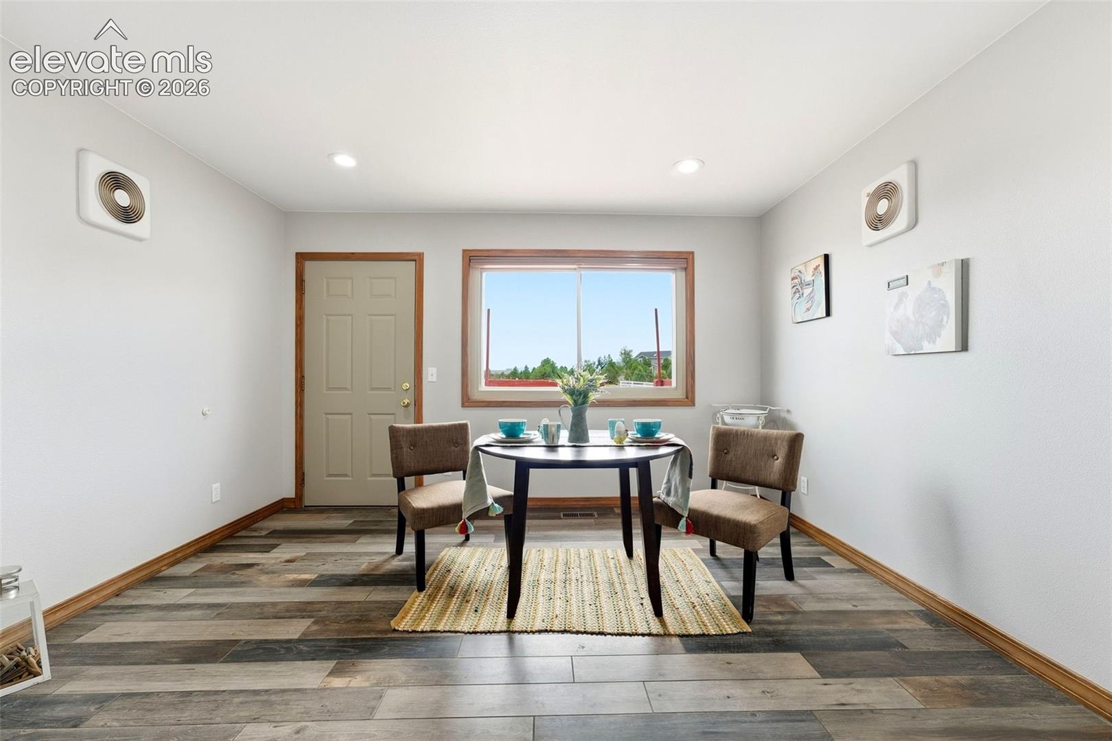 Recessed lighting, wood-finish flooring, wood trim, white walls, and a multi-pane window