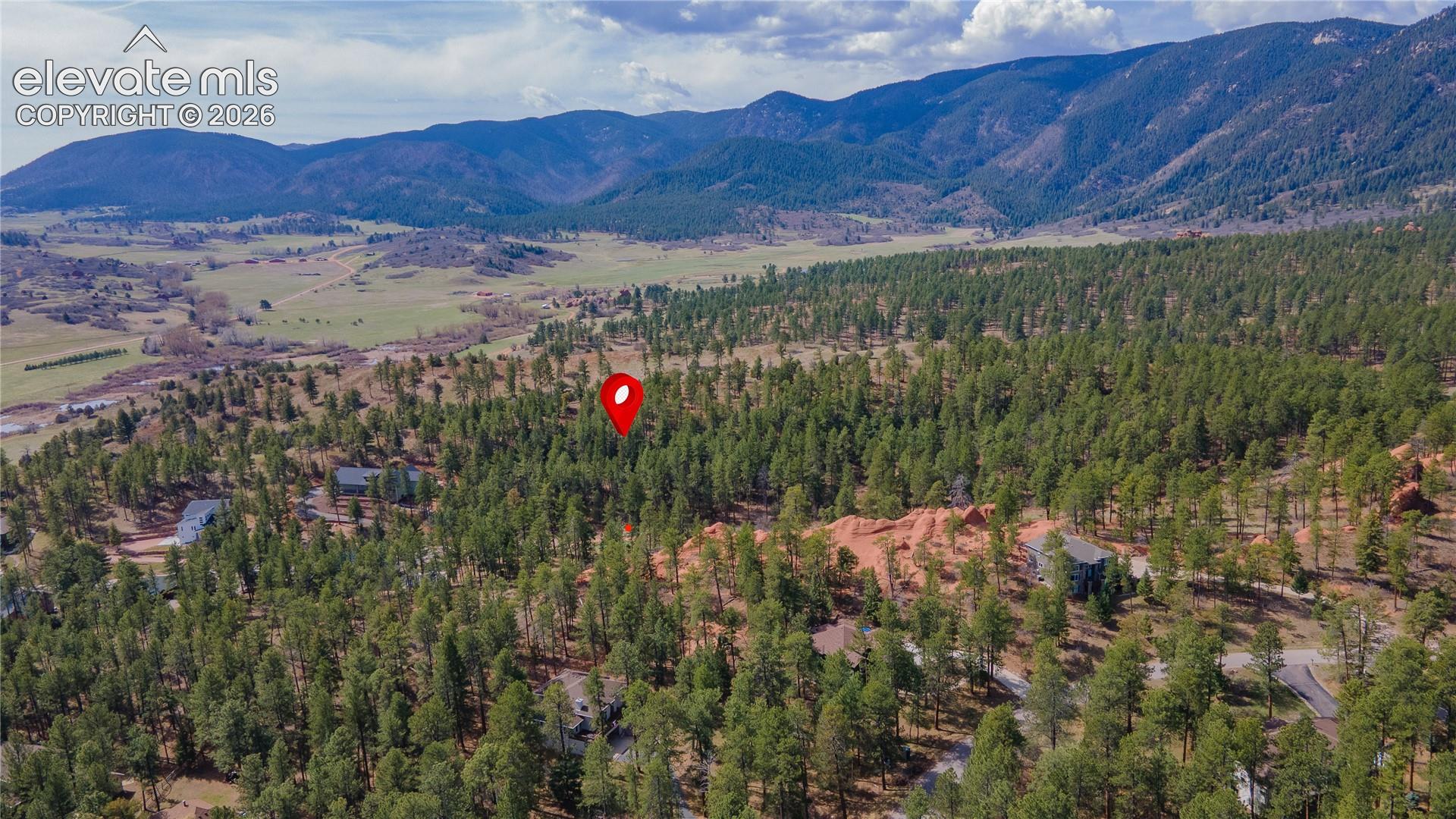 Expansive wooded lot with a mountain backdrop, surrounded by mature trees