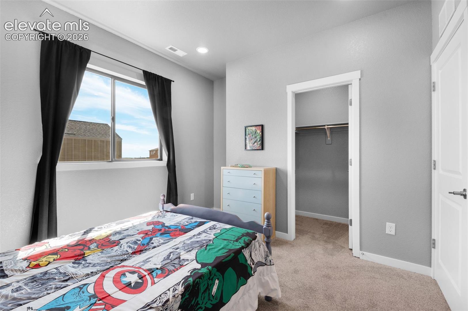 Window with natural light, wall-to-wall carpeting, overhead recessed lighting, and a closet with built-in shelving