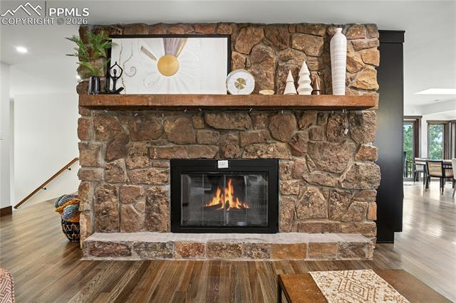 Detailed view of wood finished floors and a stone fireplace