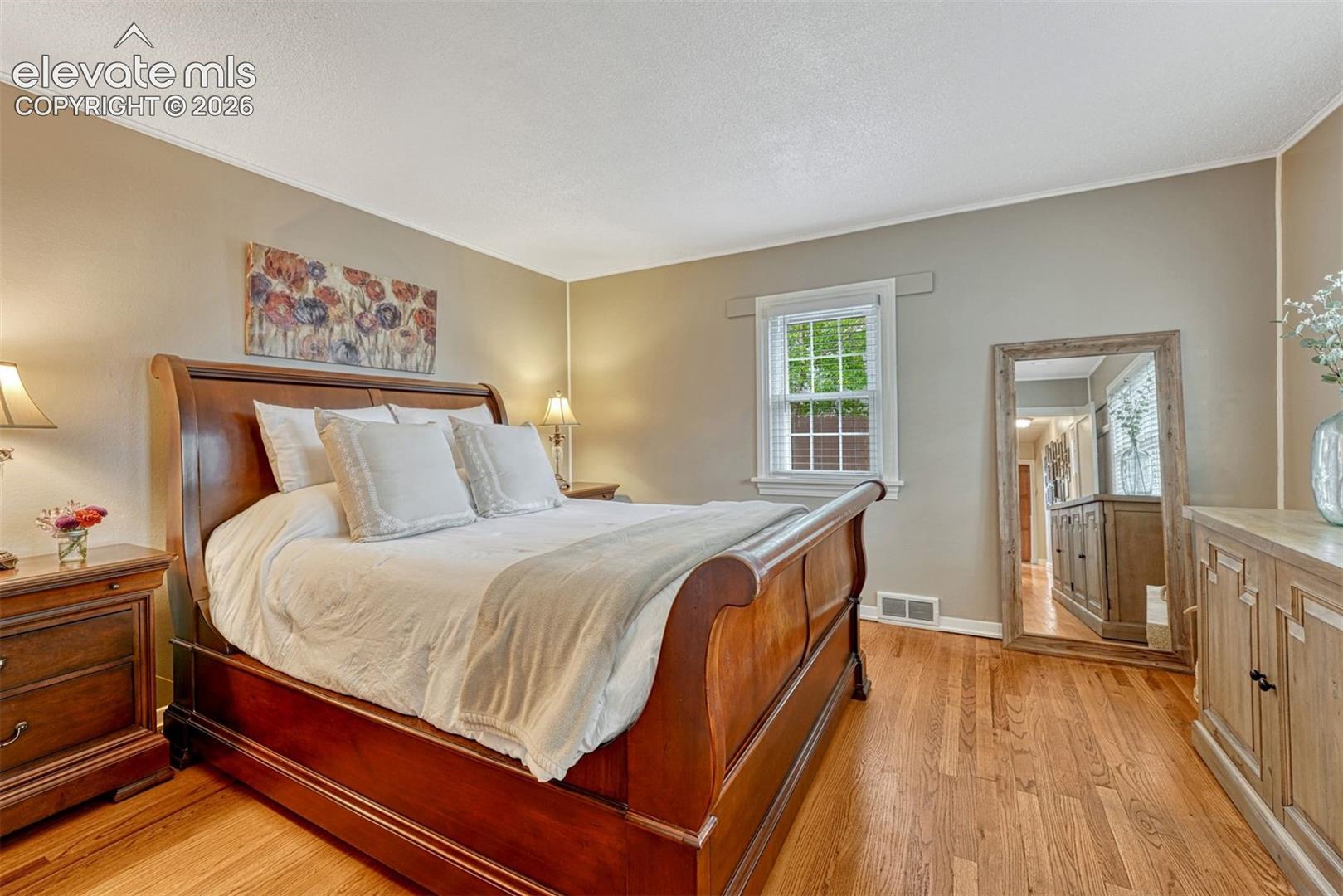 Light-filled primary bedroom with a wall of windows.