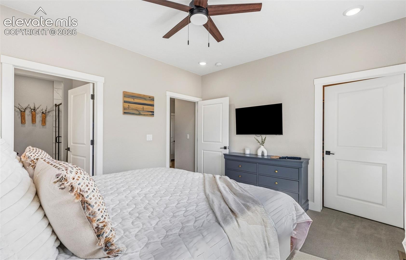 Primary Bedroom w/ walk-in closet on the right, hallway door center and ensuite bathroom on the left