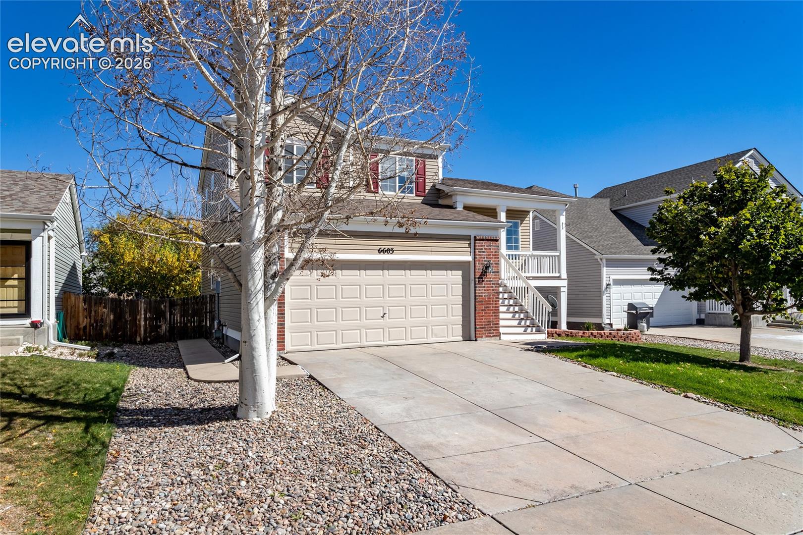 A centered aerial perspective demonstrating the home's level lot, clean landscaping, and private fenced back lawn
