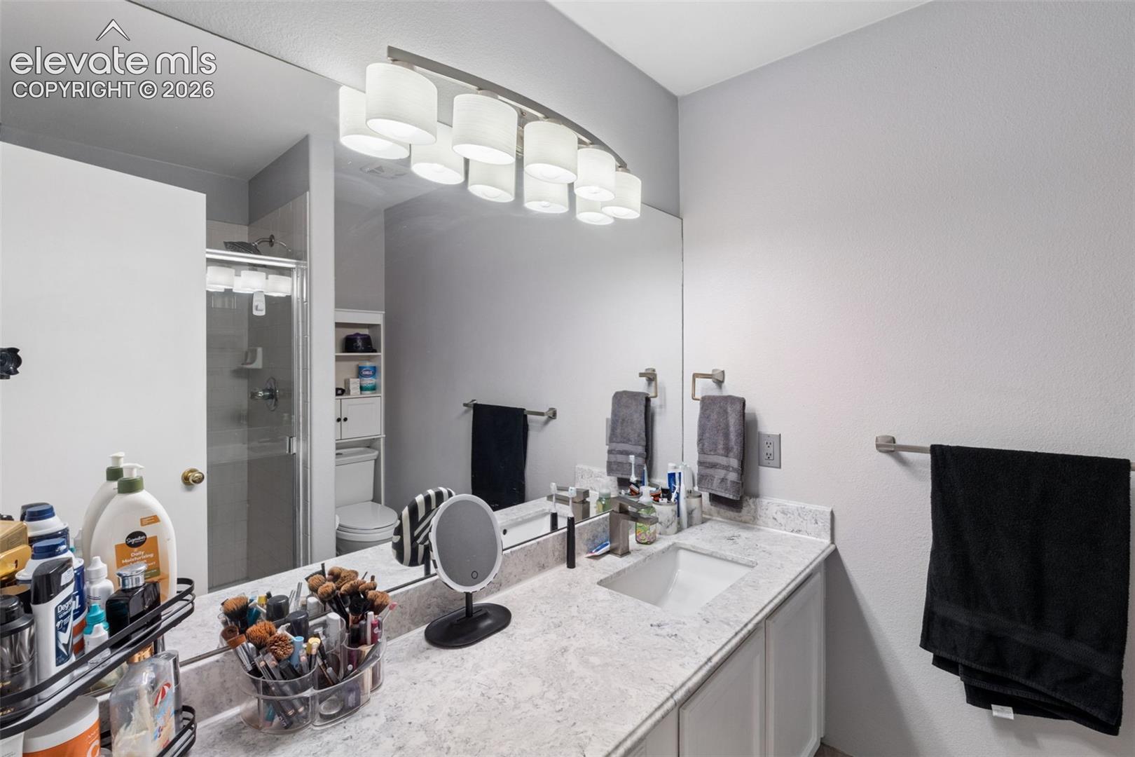 Vanity with an integrated rectangular sink, granite-style countertop, and a large wall-mounted mirror
