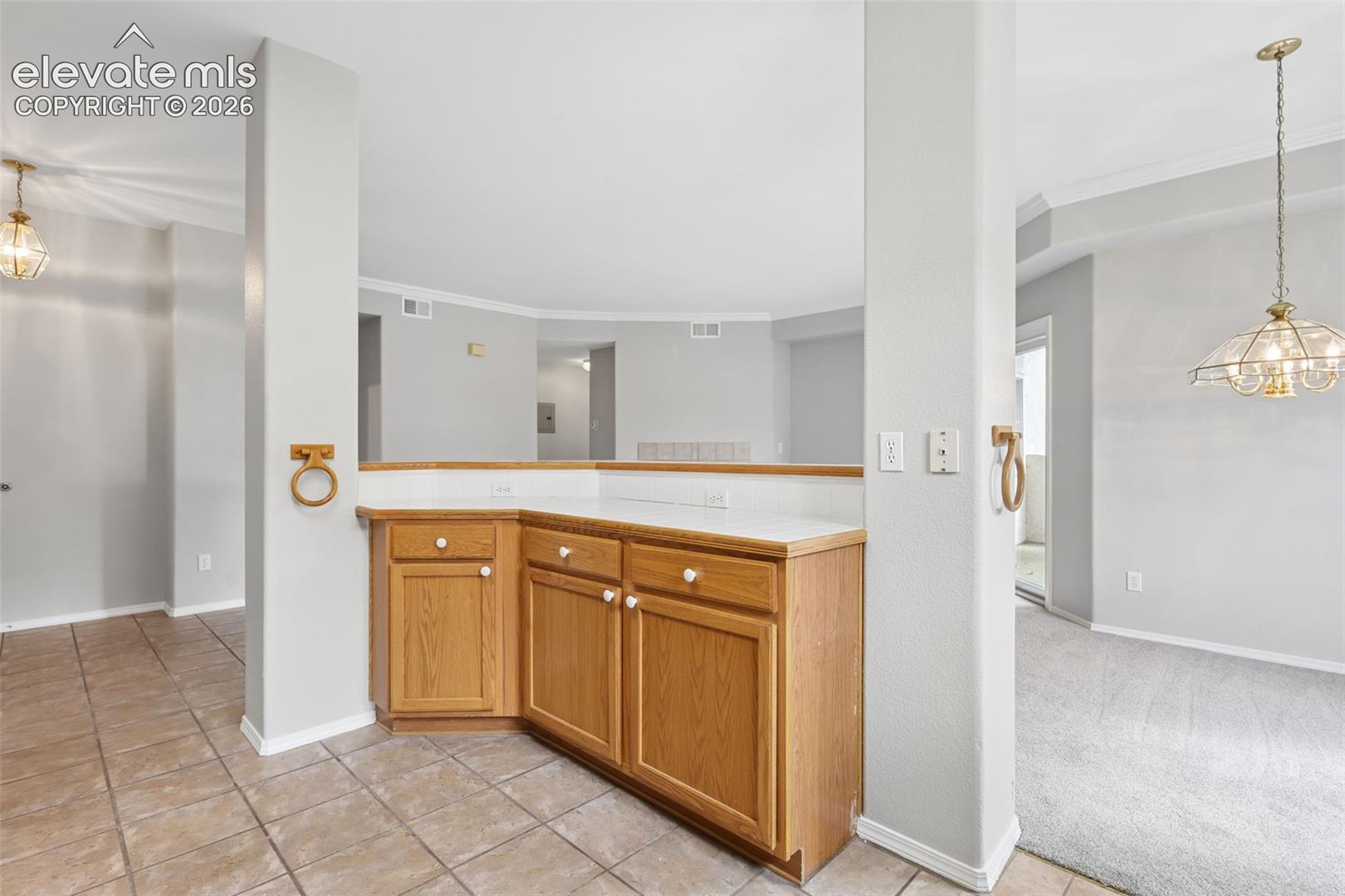 Built-in cabinetry with light wood finish and white countertops