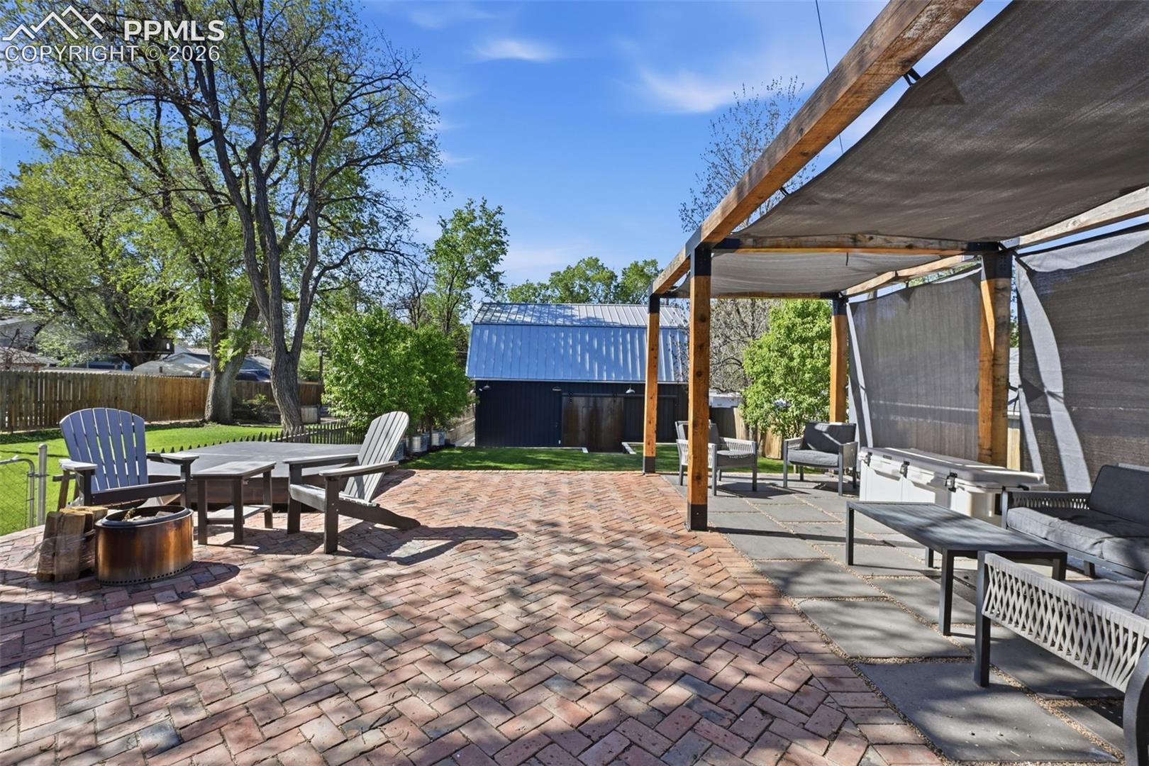 Covered pergola is complete with a brick and paver porch, and room for a firepit.  