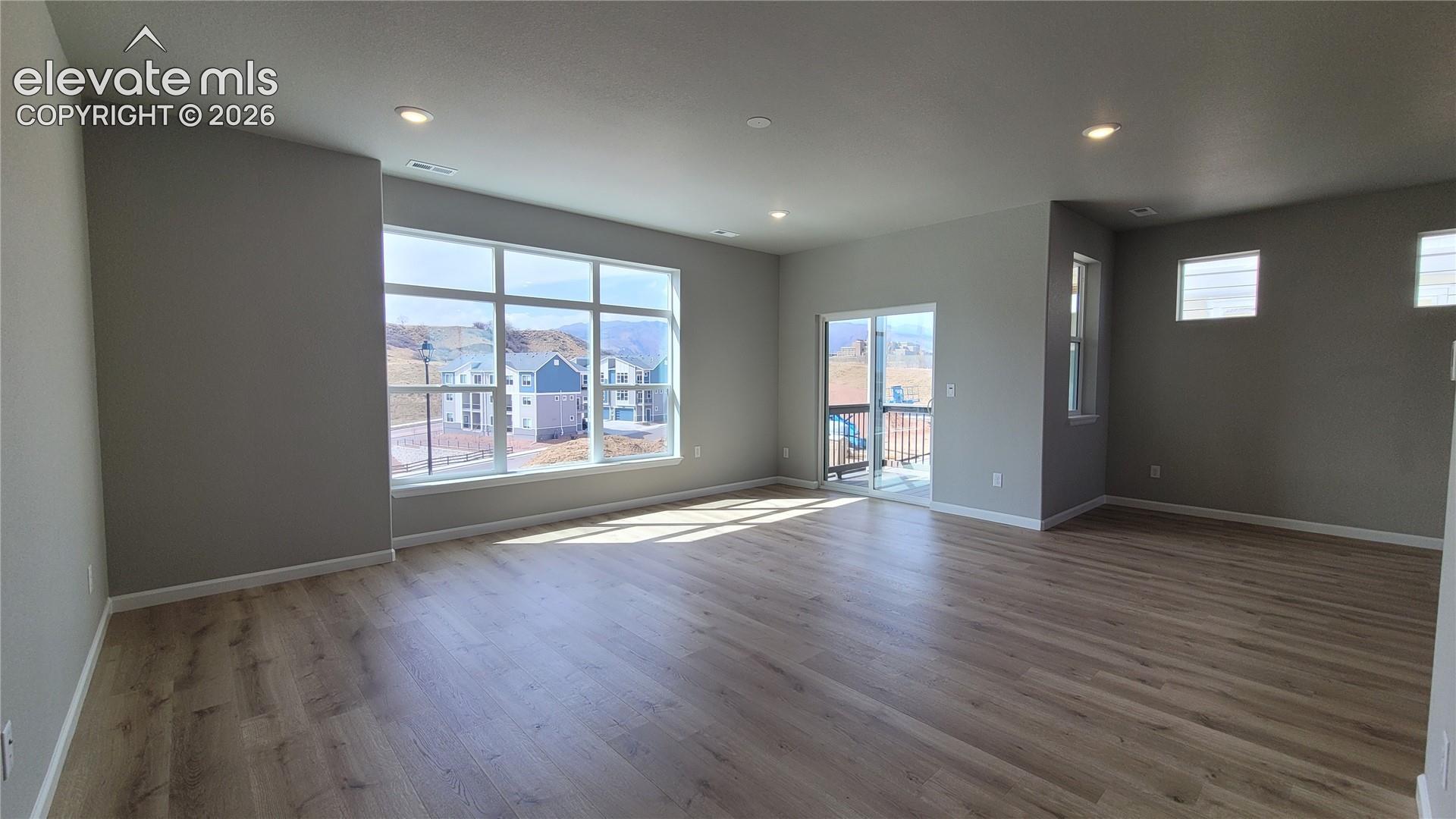 Spacious Living Room with LVP flooring, abundance of natural light, walks out to composite deck!