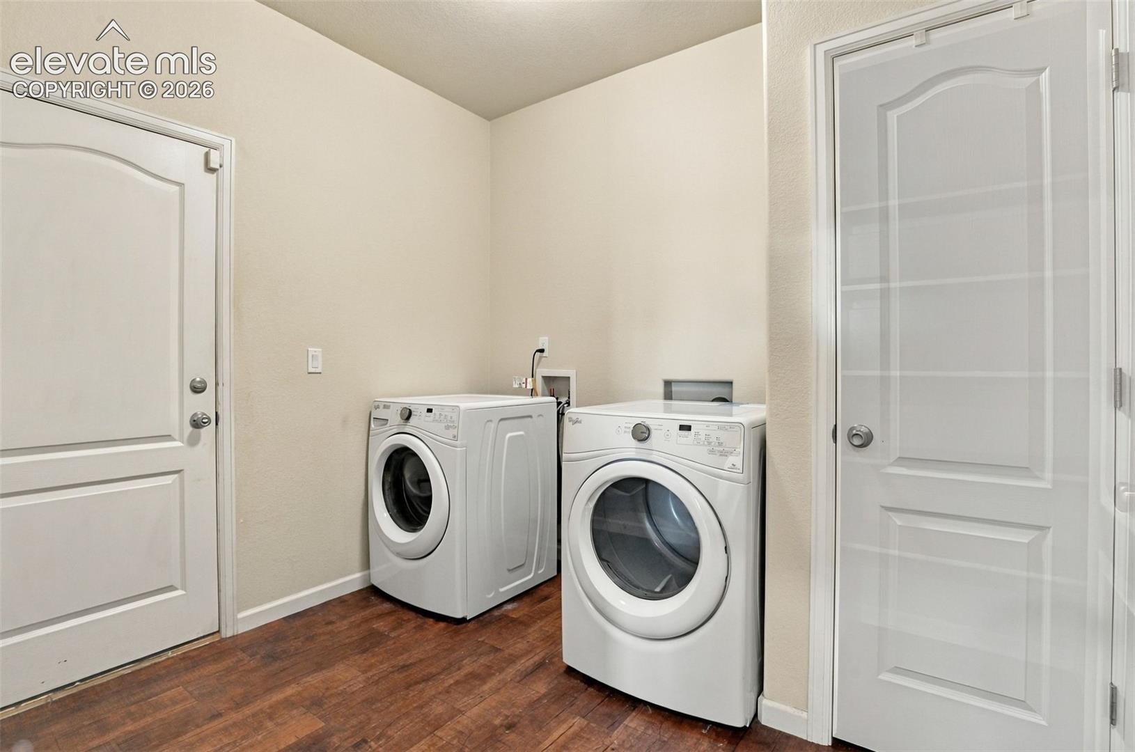 Laundry area featuring wood-finish flooring, white paneled doors, and dedicated appliance hookups