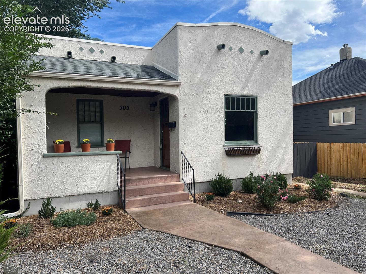 Main House - Stucco exterior with an arched entryway and covered porch