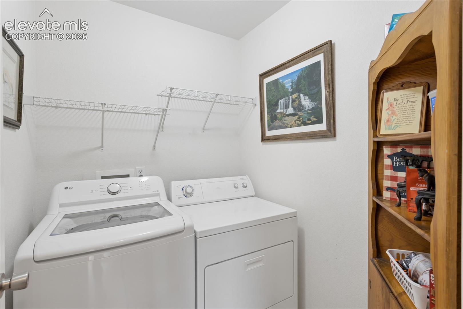 White washer and dryer appliances with overhead wire shelving