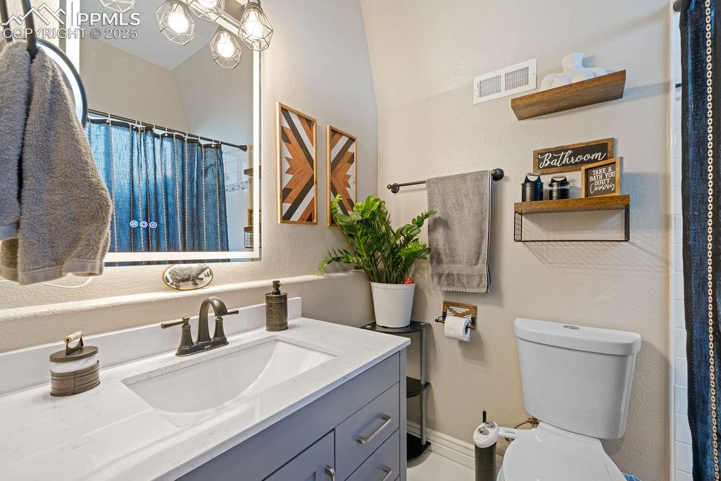 Bathroom featuring a shower with curtain, vanity, and a textured wall