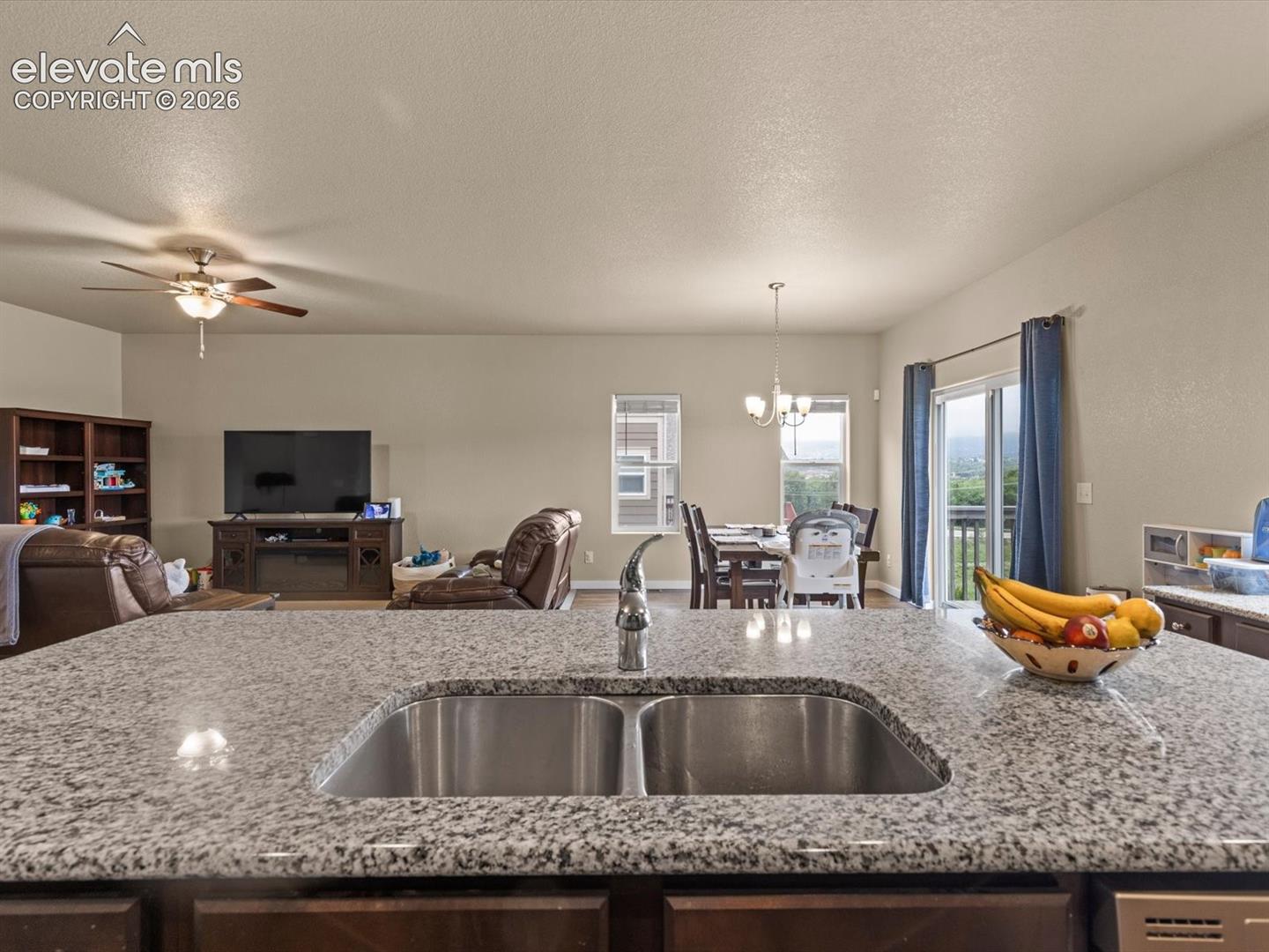 Granite countertop island featuring a double stainless steel sink