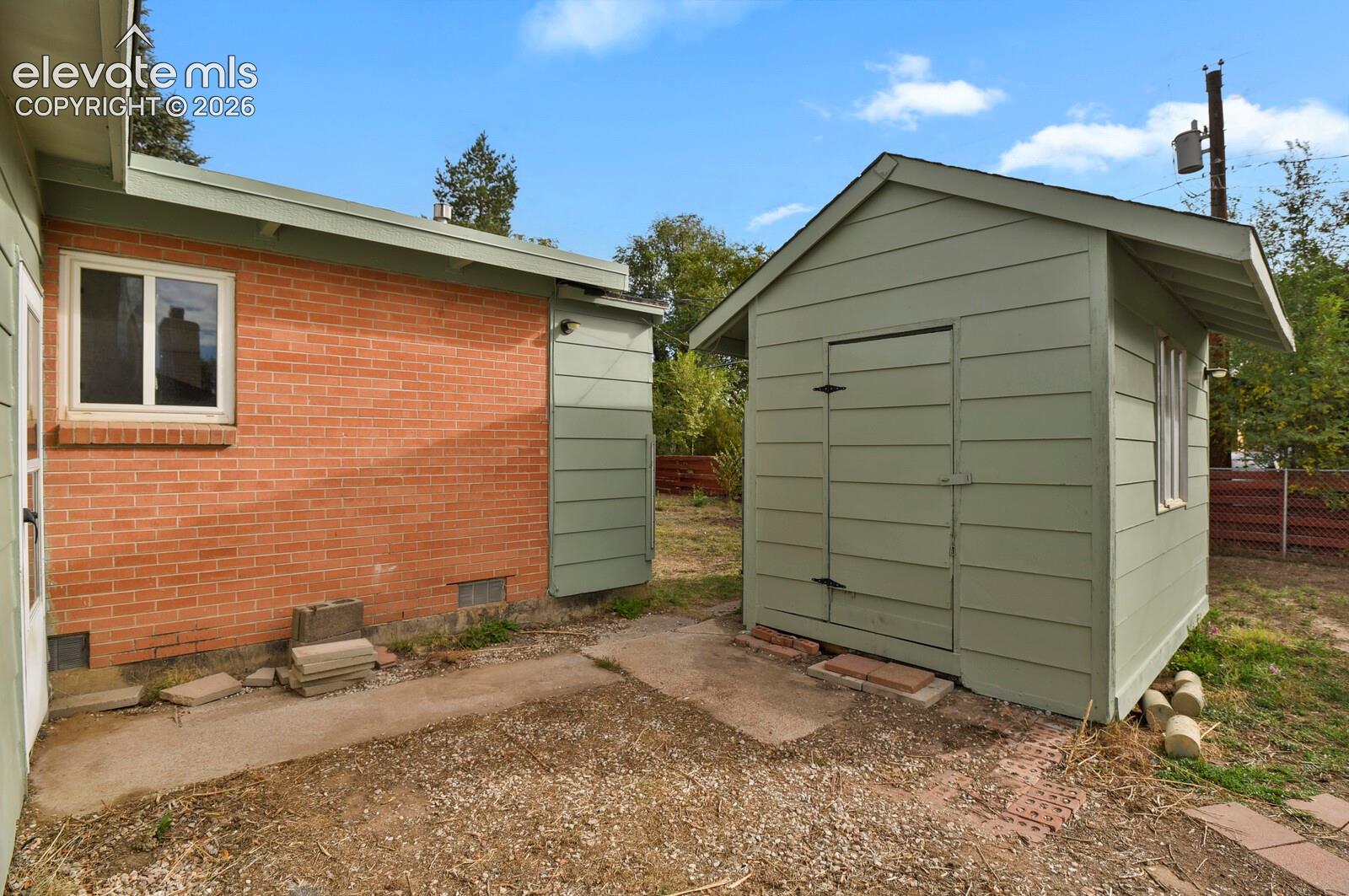 Exterior features include a brick and lap-siding facade, a detached 11x7' storage structure with matching siding, and a large 20x30' fenced Dog run.