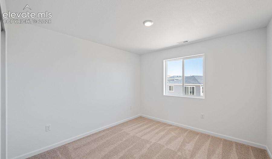 Neutral interior room featuring neutral-toned carpeting, white walls, a single-pane sliding window, and a recessed ceiling light